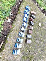 Top view of two rows of glazed ceramic pot feet showing quantity and color variety