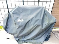 Weber-branded fitted grill cover on grill