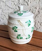 Front view of Belleek shamrock marmalade jar showing shamrock decoration and barrel form