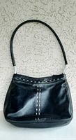 Front view of black leather Derek Alexander purse showing white stitching and shoulder strap