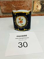 Front view showing floral medallion and gold trim