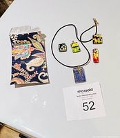 overview of five pendants and cord with pouch