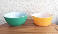 Green and orange Pyrex bowls side by side on table
