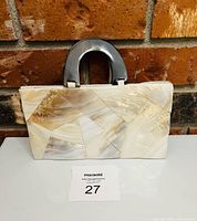 Front view of shell mosaic handbag with dark handles