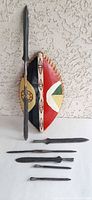 Full view of painted shield with long blade and five loose blades