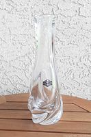 Full view of clear Saint Louis crystal bud vase on wood surface