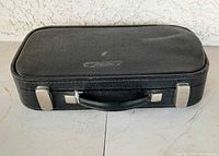 Closed black textured clarinet case with handle and metal latches