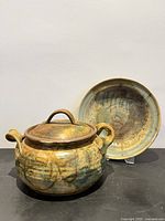 Casserole with lid removed and plate behind showing glaze and form