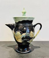 Front view of ceramic teapot showing glaze pattern, lid and finial