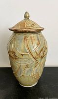 Front view of lidded ceramic vessel showing texture and glazing