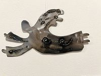 Full view of metal flying angel hanging on wall