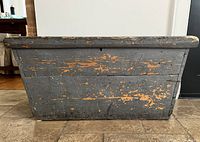 Front view of grey distressed pine blanket chest showing tapered shape and chipped paint
