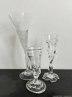 Three clear blown glass vessels standing side by side