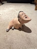 Front-side view of figurine showing animal body and caricature head