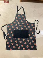 Front view of apron showing logo pattern, pocket, straps