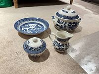 Full set of four blue willow Churchill pieces displayed on carpet