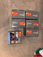 Six grey retail boxes of curtain light sets stacked on carpet