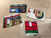 Four folded printed cotton panels on floor, showing distinct holiday designs