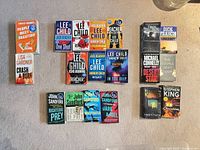 All 18 paperback novels laid out on carpet, showing full covers for identification