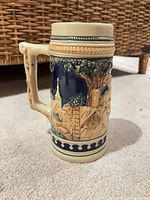 Left side view showing handle, church and village relief