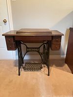 Full front view of Singer treadle sewing machine cabinet closed