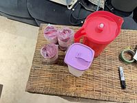 Overall lot showing pitcher, slim container and three tumblers on table