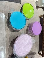 Top view of all four lidded bowls (green, blue, purple, pink)