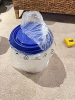 Nested canisters wrapped in original plastic bag, top blue lid visible
