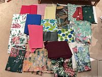 Overview of all fabric pieces laid on floor showing variety of colors, patterns and sizes