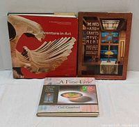 Front view of three art books: Adventure in Art, The Arts and Crafts Movement, A Fine Line