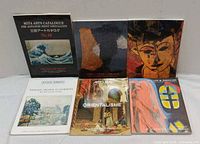 Front covers of all six art books standing upright