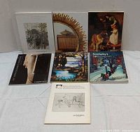 Seven auction catalogues laid out showing covers