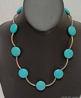 Necklace on display bust showing front view of turquoise beads and silver tubes