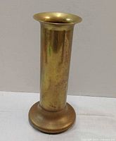 Front view of brass cylindrical holder with flared rim and round base