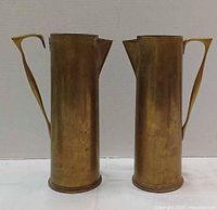 Front view of both brass pitchers