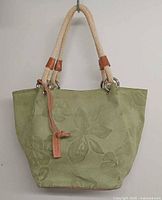 Front view of green suede tote with rope handles