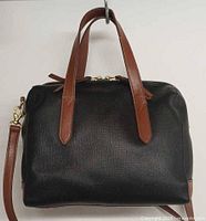 Front view showing black PVC body, brown handles, gold hardware