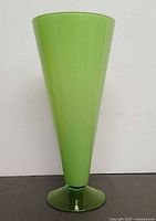Full front view of green footed art glass vase