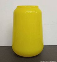 Full front view of yellow glass vase standing upright