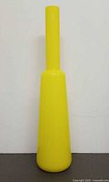Full front view of tall yellow art glass vase standing upright