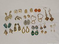 All eighteen pairs of costume earrings arranged on white background