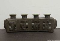 front view showing four taper cups and textured square motifs