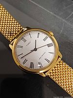 Front view of gold-tone Timex watch showing white Roman-numeral dial