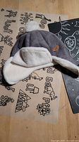 Gray infant aviator hat with white fleece lining and pom-pom
