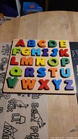 Full view of wooden alphabet puzzle board showing all letters A–Z in place