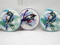 Front view of the three round ceramic bird ornaments