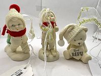 Three Snowbabies ornaments standing side by side