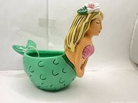 Right-side view of mermaid planter showing green tail bowl and drainage plug tag
