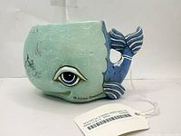 Front view of ceramic whale planter showing eye detail and Allen Designs mark