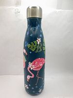 Front view of teal bottle showing flamingo and floral design